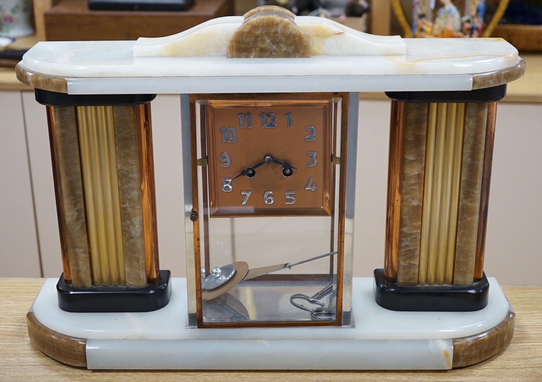 An Art Deco chrome, copper, brass and alabaster four glass mantel clock, 54cms wide